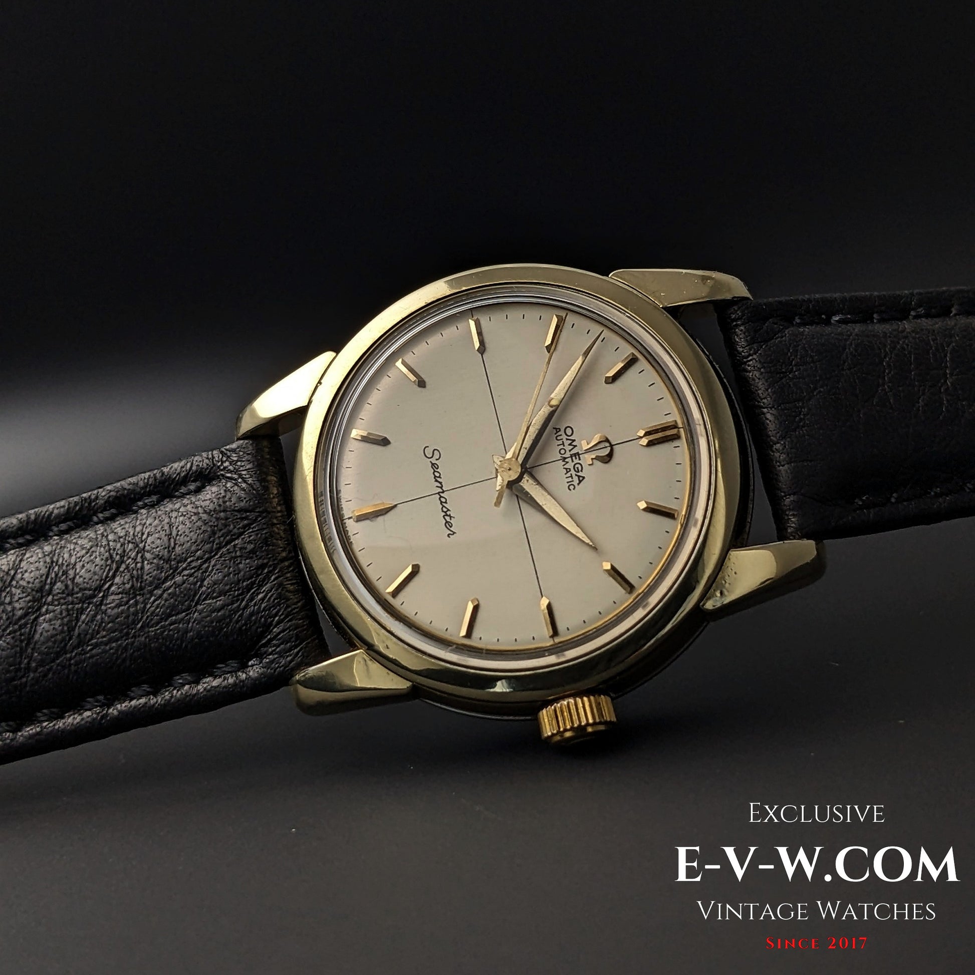 Close-up of 67-Year-Old Omega Seamaster Ref. 2828-9SC Cal. 471 with polished gold-tone bezel and black leather strap on dark background.