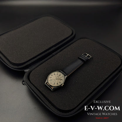 Omega FAB SUISSE Ref. 2750-6 vintage wristwatch inside an open black protective case. A 1954 Swiss-made timepiece with a silver dial.