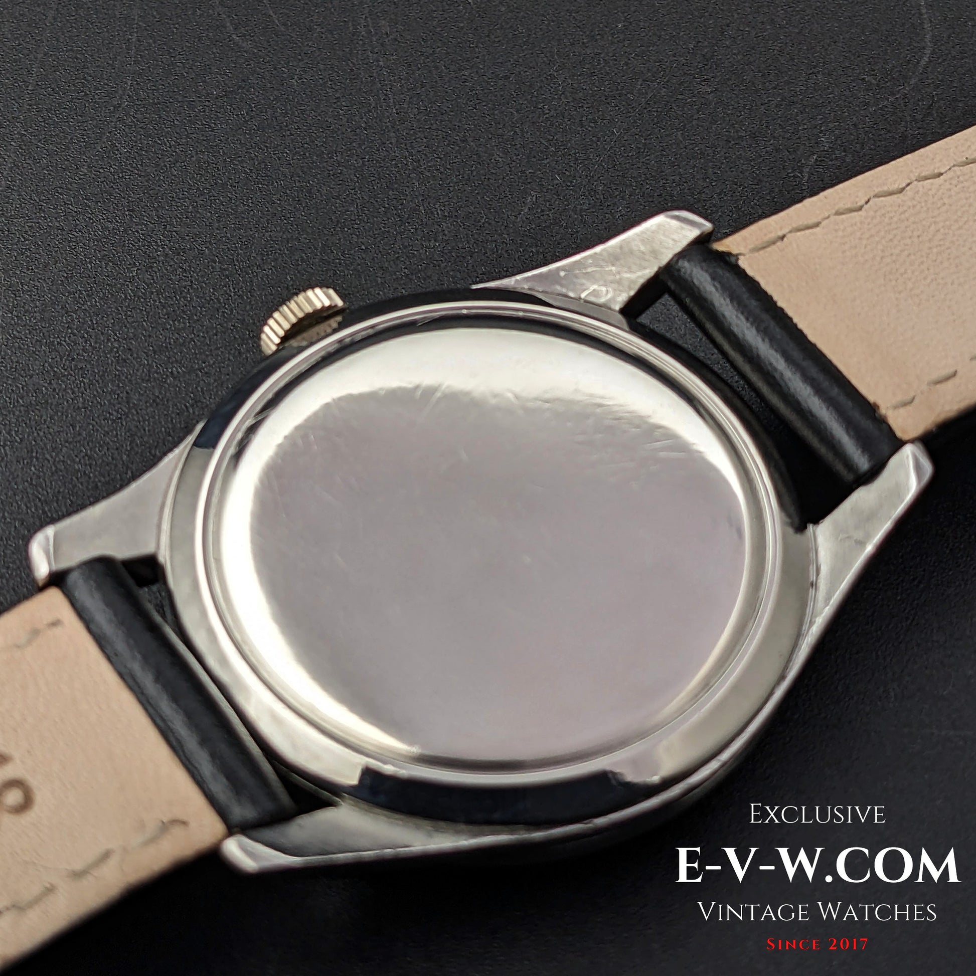 Back view of the Omega FAB SUISSE Ref. 2750-6 vintage wristwatch, featuring a polished stainless steel case and black leather strap.