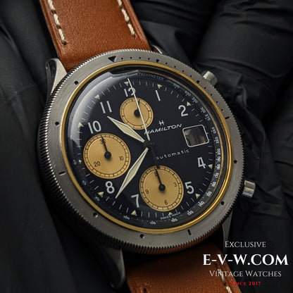 Vintage Hamilton Lancaster Chronograph with black and gold dial, automatic movement, and brown leather strap, ideal for collectors.