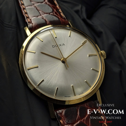 Buy DOXA Vintage 14k Gold Watch 1950 with silver sunburst dial, minimalist gold indices, and brown leather strap, perfect for collectors of classic timepieces.
