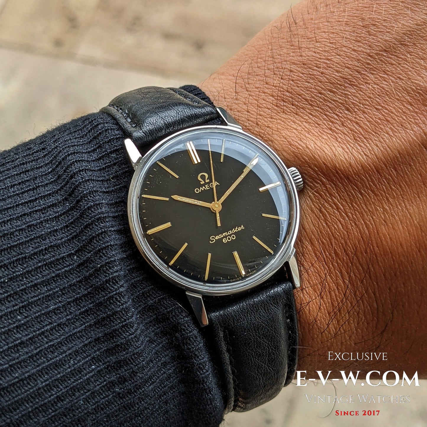 1966 Vintage Omega Seamaster 600 Ref. 135011 worn on wrist, showcasing its elegant black dial and gold-tone hands with black leather strap.