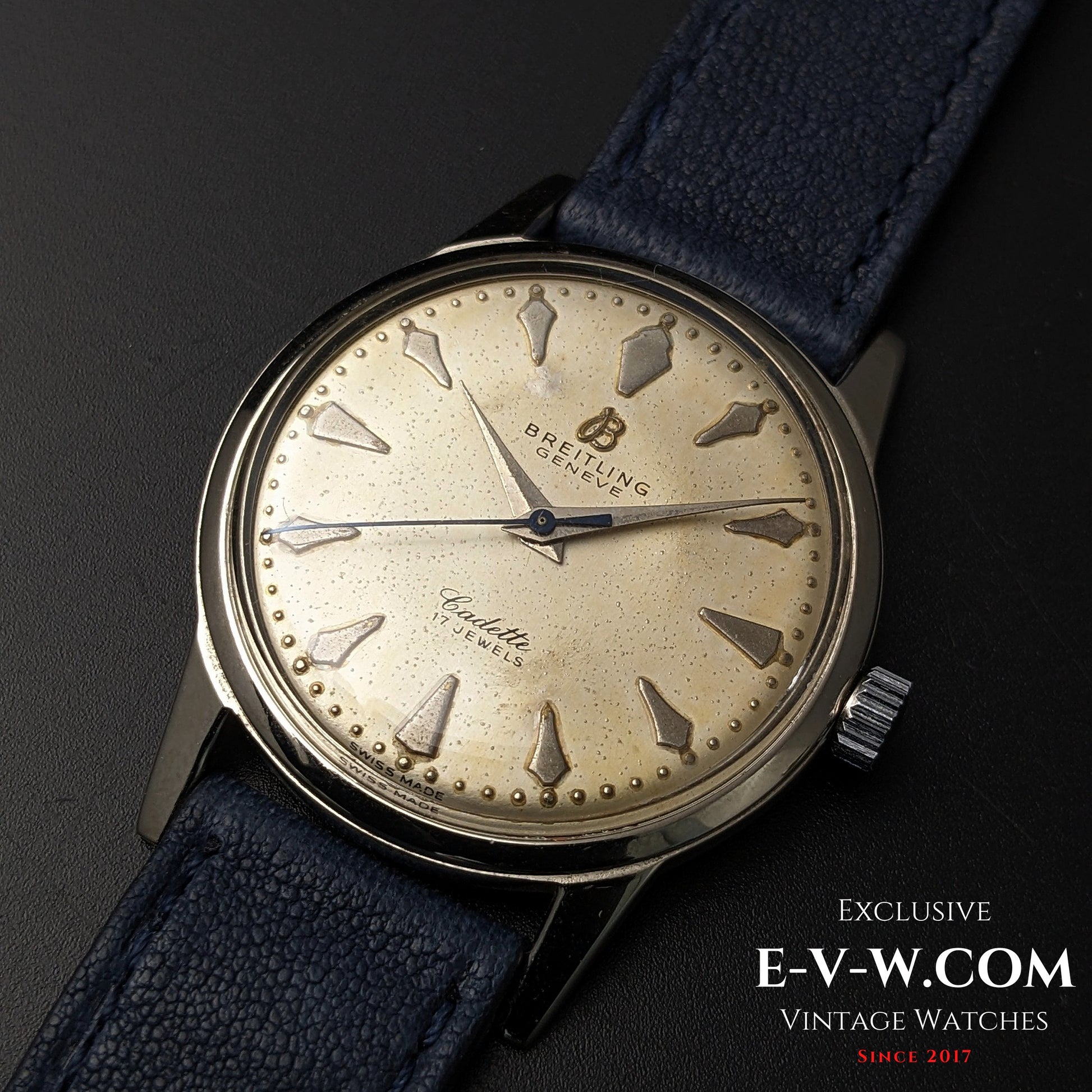 Close-up of Vintage Breitling Geneve Cadette Watch 1960s highlighting patina on dial and 17-jewel movement with blue leather strap.