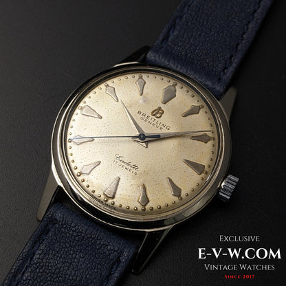Close-up of Vintage Breitling Geneve Cadette Watch 1960s highlighting patina on dial and 17-jewel movement with blue leather strap.