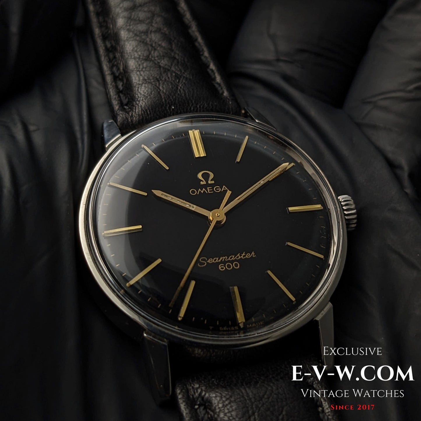 Detailed close-up of Omega Seamaster 600 1966 Ref. 135011 with black dial, gold indices, and polished case on black leather strap.