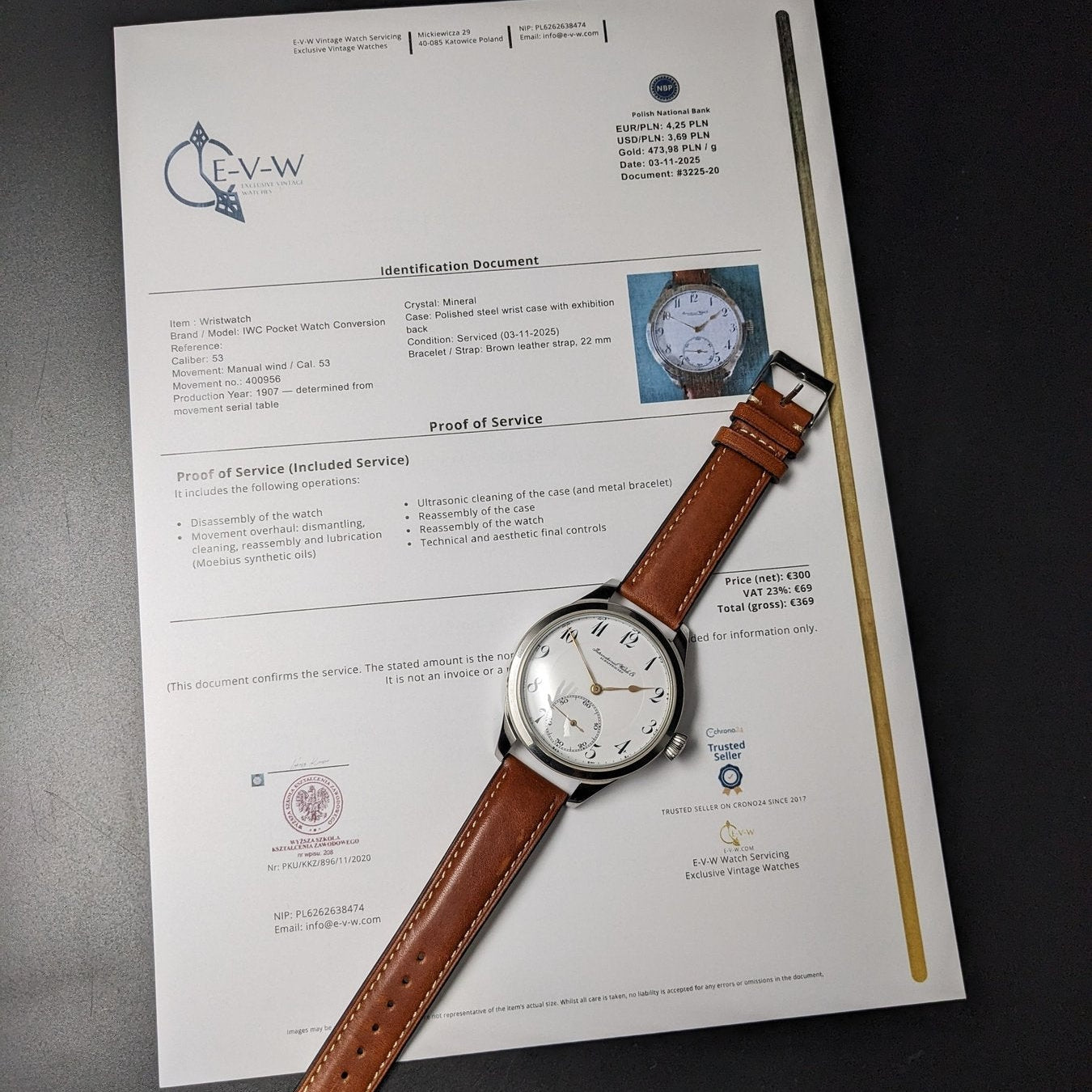 Watch with brown leather strap on a document with text and logos