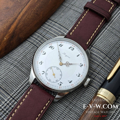 Vintage watch with brown leather strap on a textured surface, featuring E-V-W.COM branding.