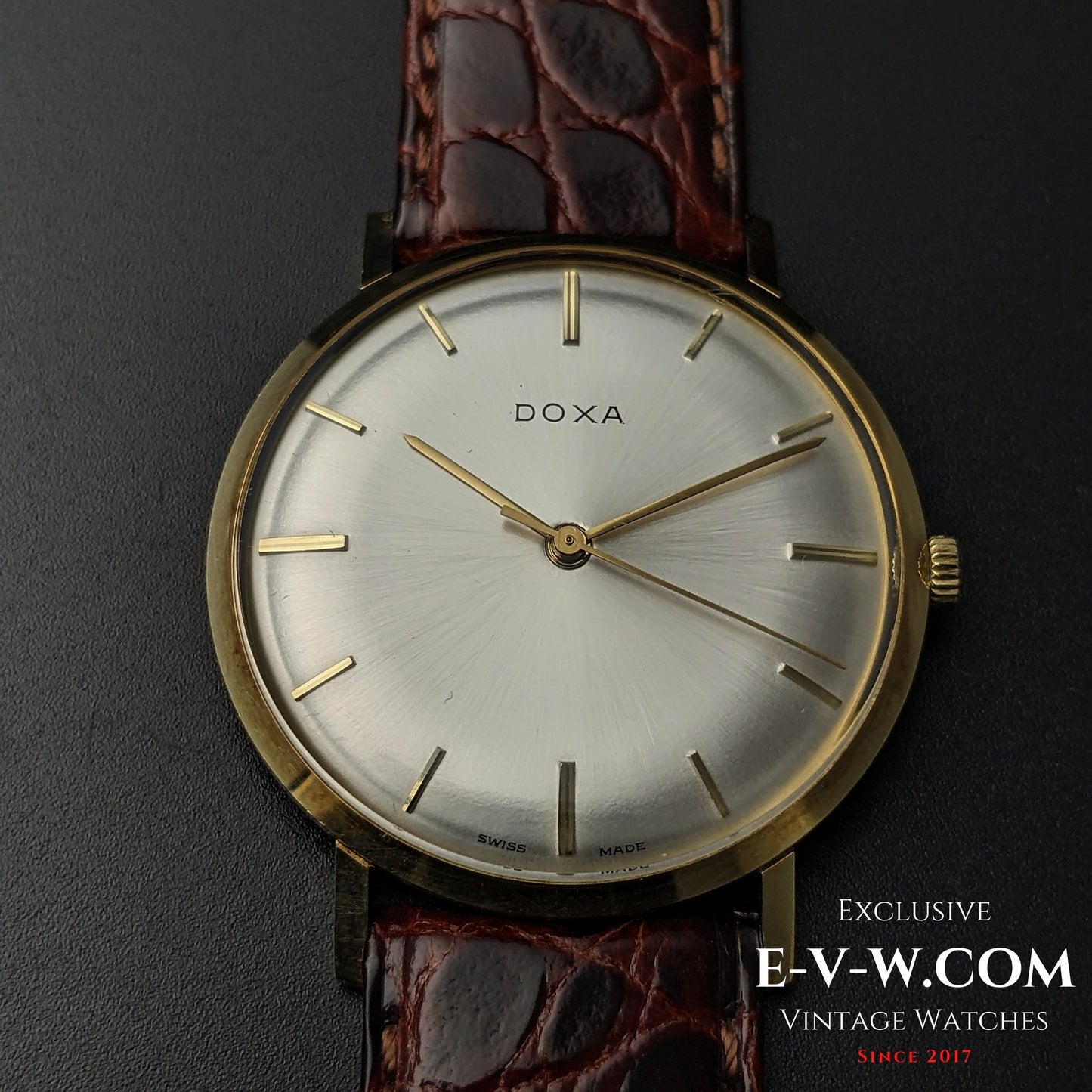 Front close-up of DOXA Vintage 14k Gold Watch 1950 with silver dial and gold baton markers, showcasing timeless Swiss design.