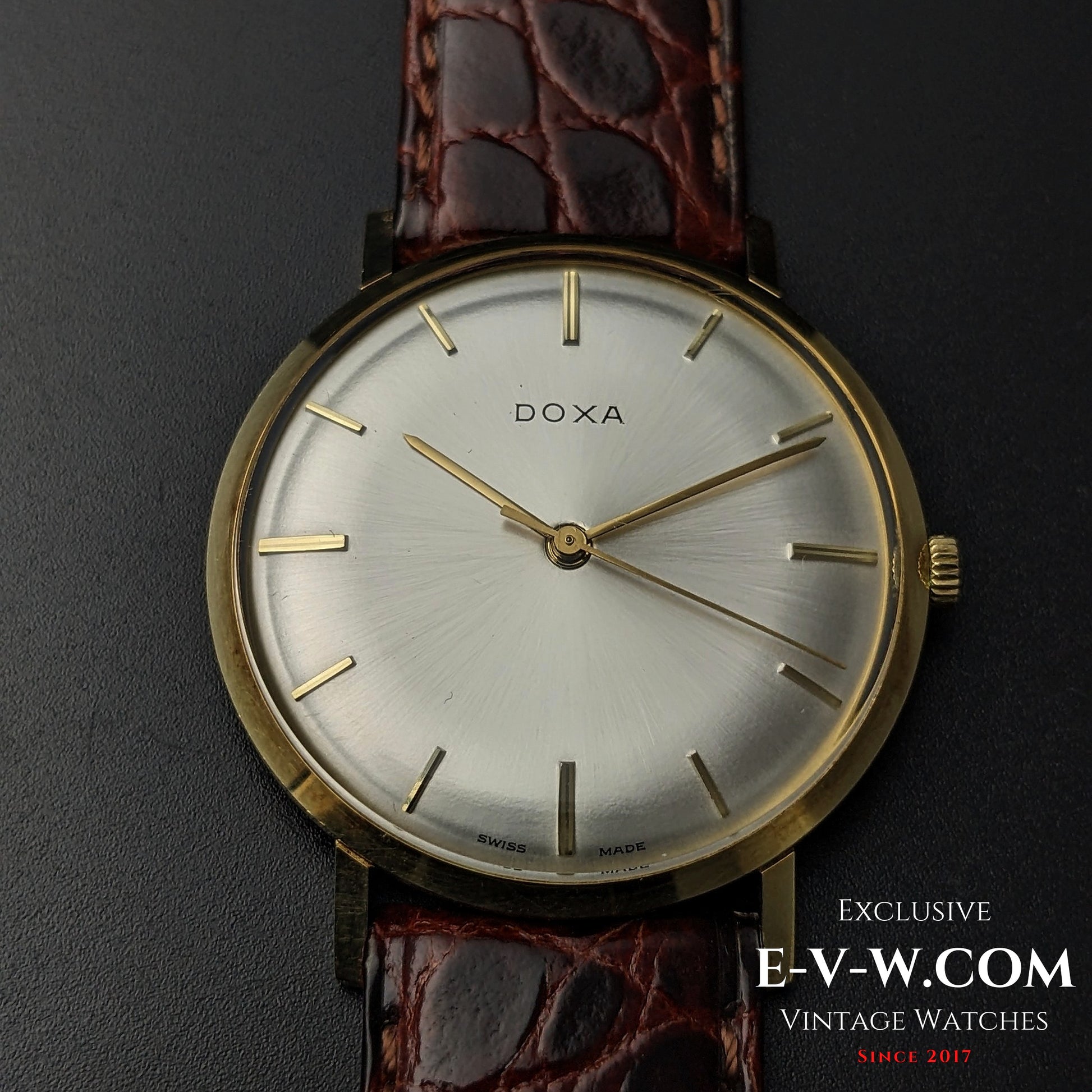 Front close-up of DOXA Vintage 14k Gold Watch 1950 with silver dial and gold baton markers, showcasing timeless Swiss design.