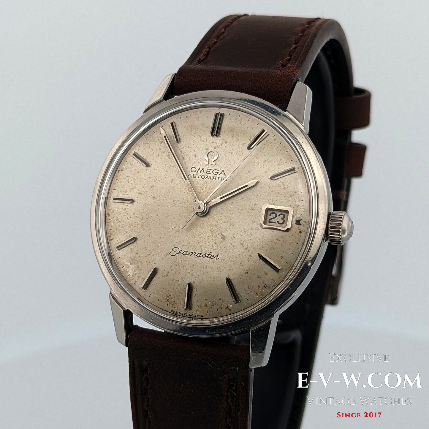 Vintage Omega Seamaster watch with brown leather strap on a light gray background